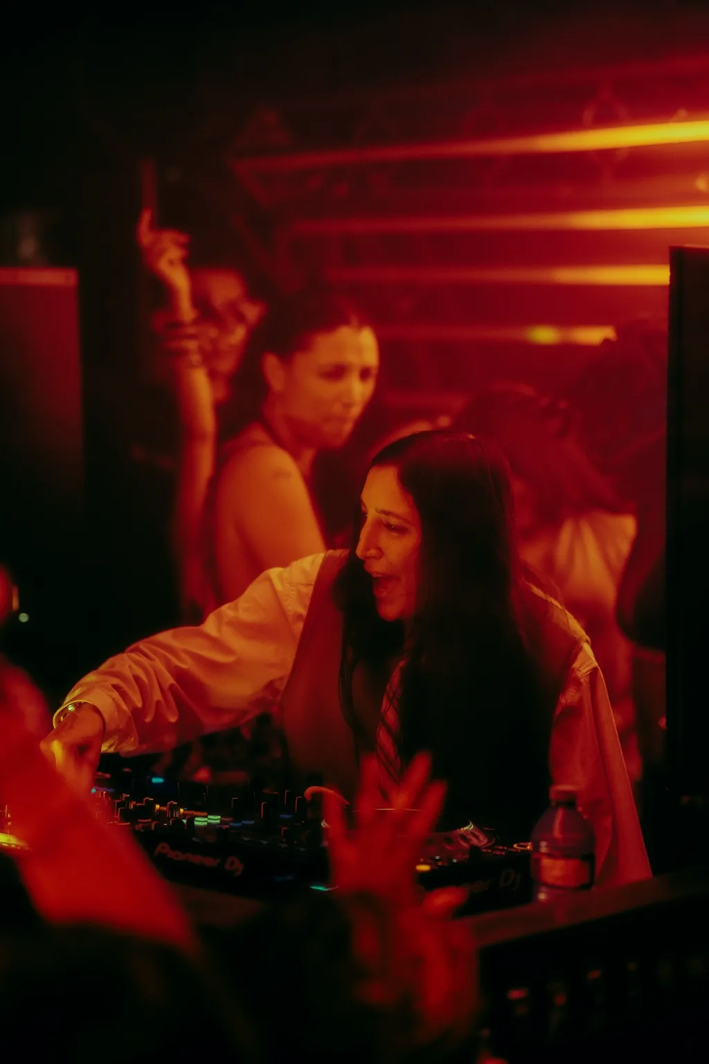 DJ performing beneath red light bars at Project Kulture.